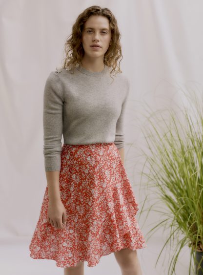 Woman wearing the Zina Wrap Skirt sewing pattern by Liberty Sewing Patterns. A wrap skirt pattern made in lightweight fabrics with drape such as cotton or silk, featuring a left sided self-waist tie and optional gathered tier.