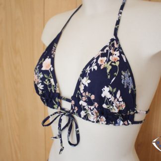 Mannequin wearing the Alizée Bikini Top sewing pattern from Etoffe Malicieuse on The Fold Line. A bikini top pattern made in swimsuit fabrics, featuring a triangular shaped cup, under bust double band with centre tie and halter neck tie.