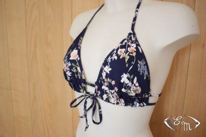 Mannequin wearing the Alizée Bikini Top sewing pattern from Etoffe Malicieuse on The Fold Line. A bikini top pattern made in swimsuit fabrics, featuring a triangular shaped cup, under bust double band with centre tie and halter neck tie.