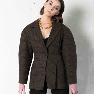 Woman wearing the Aveline Blazer sewing pattern by Vikisews. A semi-fitted jacket pattern made in wool suiting, gabardine, denim or heavy linen suiting fabrics, featuring an accentuated waist, bust and shoulder darts, a notched lapel style collar, one button fastening, dropped shoulders and a convex curve on the outer seam of the sleeves.