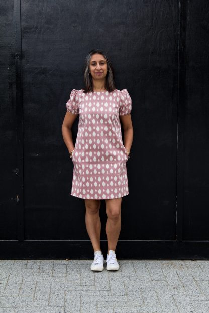 Woman wearing the Corey Dress pattern from Make With Mandi on The Fold Line. A shift dress pattern made in cotton, linen, viscose, linen blends or poly blend fabrics, featuring bust darts, boat neck, short puffed sleeves with elasticated cuff, inseam pockets and above knee length.