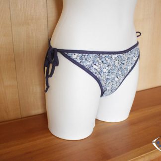 Mannequin wearing the Délice Bikini Bottoms sewing pattern from Etoffe Malicieuse on The Fold Line. A swimsuit bottom pattern made in swimsuit fabrics, featuring medium back coverage and narrow ties at either side.