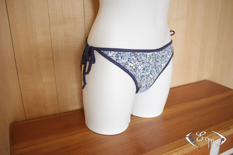 Mannequin wearing the Délice Bikini Bottoms sewing pattern from Etoffe Malicieuse on The Fold Line. A swimsuit bottom pattern made in swimsuit fabrics, featuring medium back coverage and narrow ties at either side.