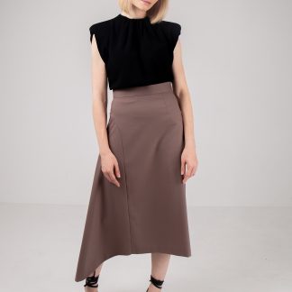 Woman wearing the Cecile Skirt sewing pattern by Vikisews. An asymmetrical, semi-fitted, lined skirt pattern made in wool, gabardine, viscose crepe, silk velvet, silk or modal fabrics, featuring a straight silhouette on the left side and a flared insert on the right, invisible side seam zip, waistband with hook and eye and below knee length.