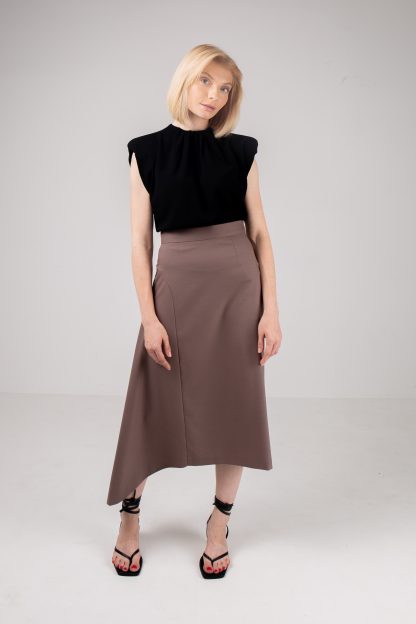 Woman wearing the Cecile Skirt sewing pattern by Vikisews. An asymmetrical, semi-fitted, lined skirt pattern made in wool, gabardine, viscose crepe, silk velvet, silk or modal fabrics, featuring a straight silhouette on the left side and a flared insert on the right, invisible side seam zip, waistband with hook and eye and below knee length.