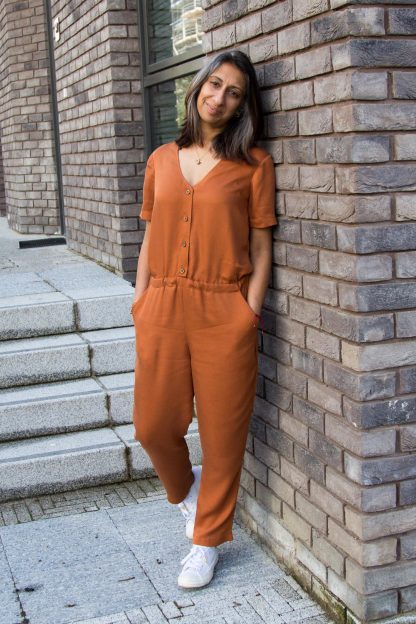 Woman wearing the Walla Jumpsuit sewing pattern from Make With Mandi on The Fold Line. A culottes/skirt pattern made in twill, viscose, linen, linen blends, chambray or lightweight stretch denim fabrics, featuring an elasticated waist, button front, relaxed fit, short sleeves, V-neck and front pockets.