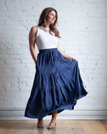 Woman wearing the Mave Skirt sewing pattern from True Bias on The Fold Line. A skirt pattern made in rayon challis, crepe, linen, cotton lawn, voile, silk, chiffon or georgette fabrics, featuring an elastic waist, self-fabric waist tie, in-seam pockets, three tiers and midi length finish.