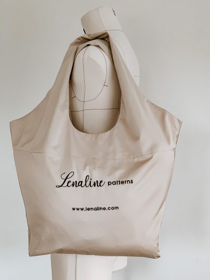 Image showing the Shopping Bag sewing pattern from Lenaline Patterns on The Fold Line. A bag pattern made in cotton, linen, wool, denim or faux leather fabrics, featuring a broad over the shoulder handle, no closures and an open single compartment.