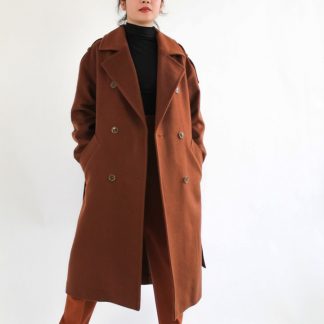 Woman wearing the Traveller Coat sewing pattern from Bella Loves Patterns on The Fold Line. A double breasted coat pattern made in wool, cashmere, boiled wool, Melton, denim, gabardine, or heavier weight linen fabrics, featuring a relaxed fit, mid-calf length, wide notched collar, dropped shoulders, welt pockets and a back vent.