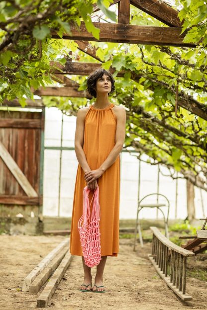 Women wearing the Ulla Dress sewing pattern from Fibre Mood on The Fold Line. A dress pattern made in woven or knit fabrics but with fluid drape, featuring a relaxed fit, calf length, halter neck using a cloth tie and slightly fitting over the bust.