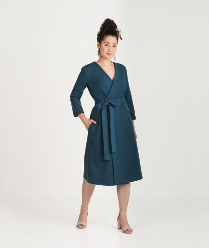 Woman wearing the Vilja Wrap Dress pattern from Tessa Roosa on The Fold Line. A wrap dress pattern made in linen, cotton lawn, double gauze, tencel or rayon fabric, featuring a 3/4 sleeves, knee length hem, in-seam pockets and V-neckline.