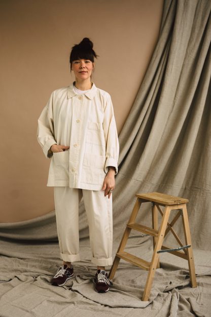 Woman wearing the Unisex ZW Workwear Jacket sewing pattern from Birgitta Helmersson on The Fold Line. A jacket pattern made in mid-heavy weight linen or cotton, light to mid weight wool coating or cotton corduroy fabric, featuring an oversize silhouette, collar, dropped shoulder, front button closure, shoulder darts and front patch pockets.