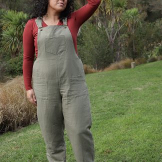 Woman wearing the Tipa Dungarees sewing pattern from Below the Kowhai on The Fold Line. A dungaree pattern made in light to medium weight cotton, chambray, linen, medium to heavy weight denim, drill or twill fabrics, featuring a relaxed fit, shaped hips with front and back darts, front and back hip patch pockets and front bib pocket.