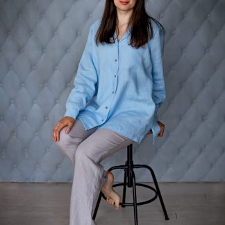 Woman wearing the Coco Shirt sewing pattern from Kates Sewing Patterns on The Fold Line. A shirt pattern made in cotton, linen, silk or viscose fabrics, featuring a wide straight cut, back yoke, front button placket, pyjama-style collar, patch pocket, cuffs and pleats on sleeves.