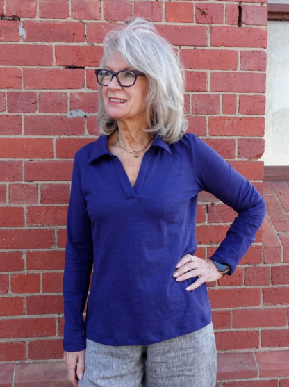Woman wearing the Raph Knit Polo Top sewing pattern from Style Arc on The Fold Line. A polo top pattern made in jersey or wool knit jersey fabrics, featuring a semi-fit, V-neck with crossover neck band, collar and full length sleeves.