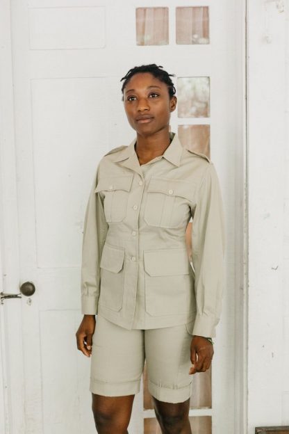Women wearing the 130 Unisex Australian Bush Outfit sewing pattern from Folkwear on The Fold Line. A unisex shorts and jacket pattern made in poplin, denim, chino, sailcloth, medium-weight linen or light-weight wool gabardine fabrics, featuring a hip length jacket with front button closure, pointed collar and lapels, front darts and shaped side-back seams, back pleats, back yoke, two piece sleeves pleated into buttoned cuffs, buckled belt, pockets and deep flap pockets. The shorts have buttoned front fly closing, pleated into wide waistband, buckled belt tabs, deep angled side pockets, button-flap back pockets and above knee turned up hems.