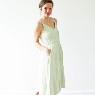 Woman wearing the Audie Playdress sewing pattern from Amy Nicole on The Fold Line. A sleeveless dress pattern made in Tencel twill, washed linen, crepe de chine, rayon challis and lighter cotton fabrics, featuring princess seams, spaghetti straps, V neckline, slash front pockets and flared tea-length skirt.