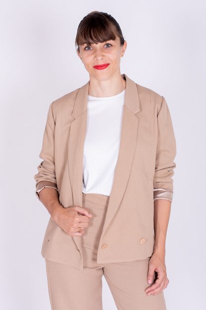 Woman wearing the Full Moon Blazer sewing pattern from I AM Patterns on The Fold Line. A jacket pattern made in jacquard, tweed, cotton twill, suiting, denim, wool crêpe, gabardine or corduroy fabrics, featuring long and narrow lapels, double-breasted with 2 button closure, full length straight sleeves and fully lined.