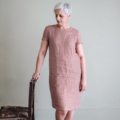 Woman wearing The Camber Dress sewing pattern from Merchant & Mills on The Fold Line. A dress pattern made in light linens, cottons, fine wool, silk or lightweight denim fabrics, featuring a tapered A-line silhouette, short fitted sleeves, round neck, knee length hem and bust darts.