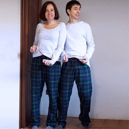 Man and Woman wearing the Unisex Pajama Pants sewing pattern from Wardrobe by Me on The Fold Line. A PJ pant pattern made in cotton, viscose or silk polyester fabrics, featuring an elastic and drawstring waist, no side seams, relaxed fit and full length leg.