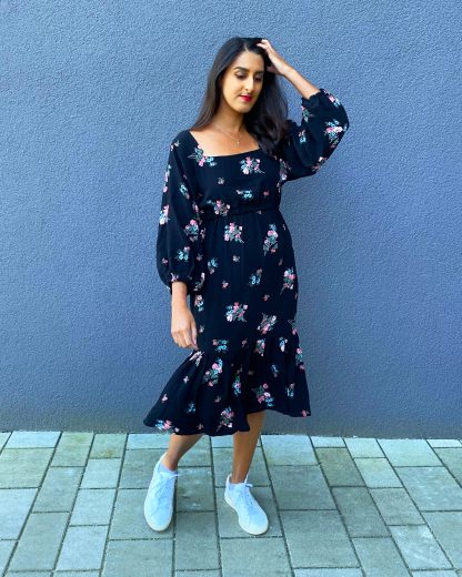 Woman wearing the Raj Dress sewing pattern from Tammy Handmade on The Fold Line. A slip-on dress pattern made in cotton, viscose/rayon, satin or crepe fabric, featuring a square neckline, elasticated waist, ¾ length sleeves with elastic at the cuff and gathered ruffle at the hem.