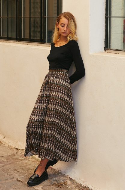 Woman wearing Calia Skirt sewing pattern from The Patterns Room on The Fold Line. A skirt pattern made in viscose, crepe or georgette fabrics, featuring a straight waistband, gathering, side seam pockets, back invisible zip closure and midi length.
