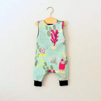 Image showing the Baby/Child Hipster Romper sewing pattern from Elemeno Patterns on The Fold Line. A sleeveless playsuit/romper pattern made in cotton knit fabrics, featuring a round neck, button shoulder fastenings and full length legs with deep ribbed hem.