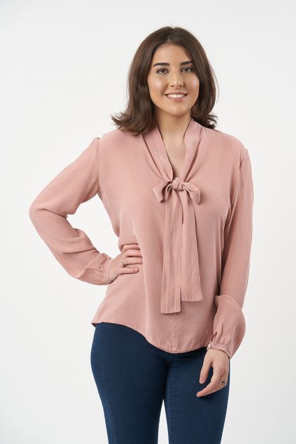 Woman wearing the Pussy Bow Blouse sewing pattern from Sew over It on The Fold Line. A blouse pattern made in rayon, viscose, crepe de chine, sandwashed silk and crepe fabrics, featuring full-length sleeves with cuff, dropped shoulder, loose-fitting dartless bodice, V-neck and self-fabric neck tie.