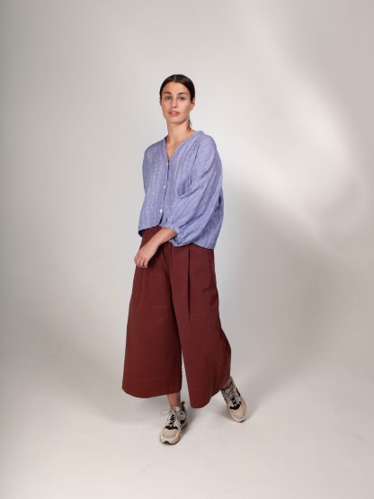 Woman wearing the ZW Block Pant sewing pattern from Birgitta Helmersson on The Fold Line. A wide legged, relaxed fitting trouser pattern made in medium-heavy weight woven cotton and linen or light-mid weight wool fabrics, featuring a waistband with inserted elastic, concealed in-seam pockets at the front and patch pockets at the back.