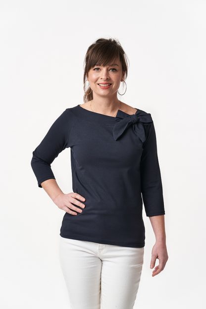 Woman wearing the Audrey Top sewing pattern from Sew Over It on The Fold Line. A knit top pattern made in light to medium weight knit fabrics, featuring a boat neckline with deep neckband and bow and raglan ¾ length sleeves.