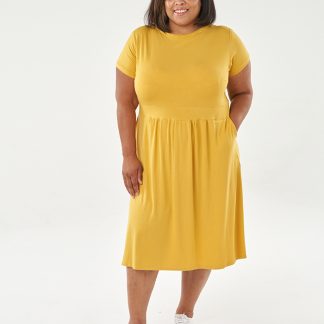 Woman wearing the Esma Dress sewing pattern from Sew Over It on The Fold Line. A dress pattern made in viscose or bamboo jersey, French terry or lightweight cotton jersey fabrics, featuring a rounded neckline, short sleeves, wide waistband, gathered skirt and below knee length finish.