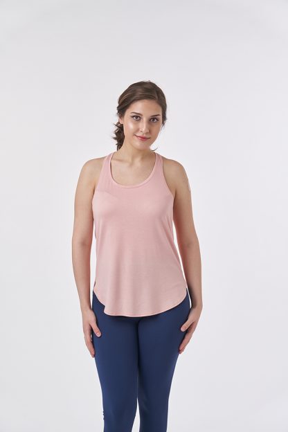 Woman wearing the Kingsly Top sewing pattern from Sew Over It on The Fold Line. A sports top pattern made in lightweight active wear knit fabrics, featuring a scoop neckline, racerback and dipped front and back hem line.