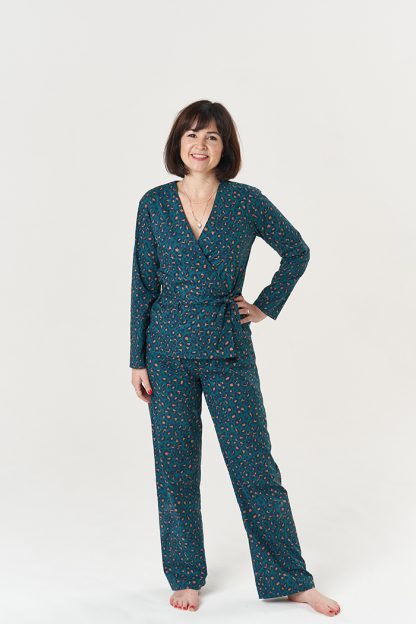 Woman wearing the Luna Pyjamas sewing pattern from Sew Over It on The Fold Line. A PJ pattern made in rayon, viscose, cotton lawn, cotton voile, double gauze or linen fabrics, featuring a wrap V-neck top, the tie threads through the side seam and wraps around the back. The trousers have no outside leg seam, at the waist the trousers are hemmed to create an elastic channel.