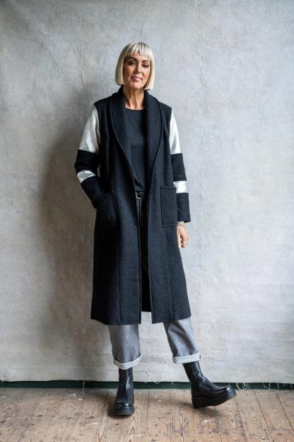 Women wearing the Rock Steady Coat sewing pattern from Sew La Di Da Vintage on The Fold Line. A coat pattern made in boiled wool fabrics, featuring patch pockets, below knee length, one banded full length and one plain sleeve, flat collar, V-neck, bust darts and no closures.