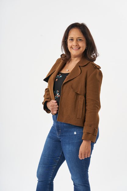 Woman wearing the Suraya Jacket sewing pattern from Sew Over It on The Fold Line. A jacket pattern made in triple crepe, Rio crepe, linen, wool and suiting wool fabrics, featuring epaulettes, storm flaps, sleeve loops, back vent, welt pockets, collar and lapels, set-in sleeves, and no closures at the front.