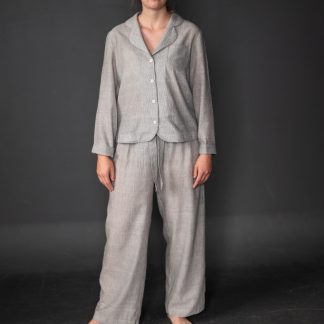 Woman wearing the Winnie Pyjamas pattern from Merchant and Mills on The Fold Line. A pyjama pattern made in linen, brushed cotton, cotton lawn, cotton poplin, Tencel or cotton double gauze fabrics, featuring long sleeves, V-neck, button front closure, breast patch pocket, long trousers with elastic waist and fabric draw string.