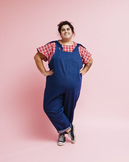 Woman wearing the Britt Dungarees sewing pattern from Melilot on The Fold Line. A dungaree pattern made in woven or jersey fabrics, featuring shoulder straps with bow-tie fastenings, side seam pockets, relaxed fit and wide legs with turn-ups.