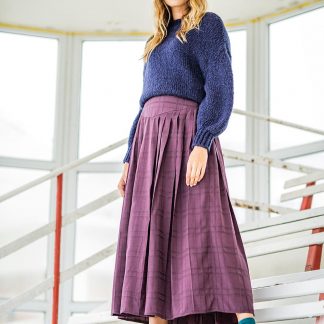 Woman wearing the Amira Skirt sewing pattern from Fibre Mood on The Fold Line. A skirt pattern made in polyester, polyamide or poplin fabrics, featuring pleats, fitted yoke, midi-length and side zip closing.