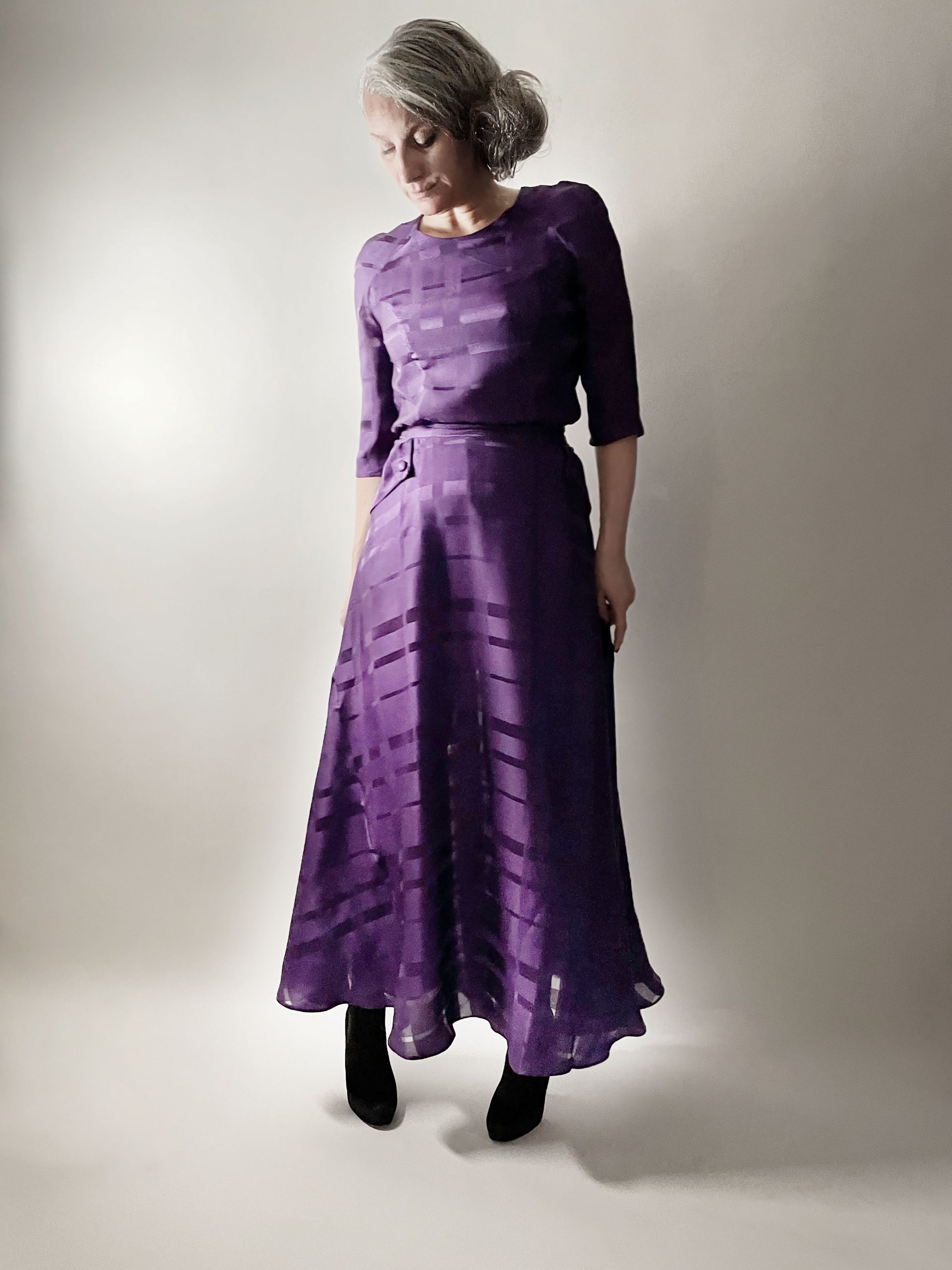 Woman wearing the No. 24 Antheuil Skirt sewing pattern from How to Do Fashion on The Fold Line. A skirt pattern made in cotton, silk, wool, viscose, cupro, Tencel, linen or polyester fabrics, featuring an A-line shape, zip closure, ankle length, waistband, slanted pockets and pocket flaps.