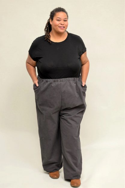 Woman wearing the Basics Pants sewing pattern from Folkwear on The Fold Line. A trouser pattern made in linen, flannel, gabardine, twill or lightweight denim fabrics, featuring an elastic-waist, relaxed fit, high-rise waist and front pockets with pocket flap detail.