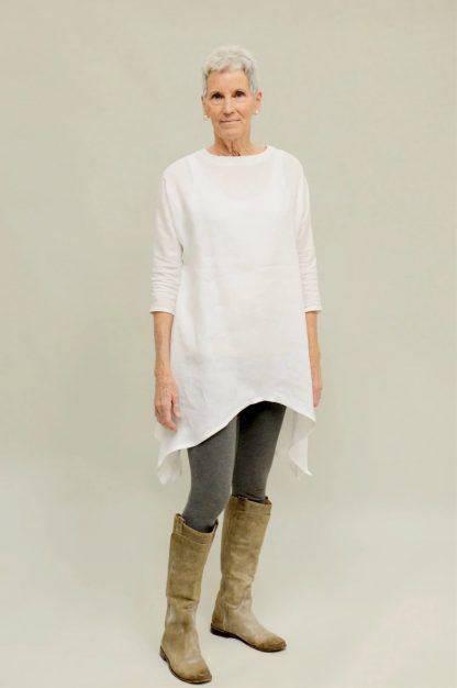 Woman wearing the Basics Tunic sewing pattern from Folkwear on The Fold Line. A tunic pattern made in linen, rayon, silk, cotton batiste, voile or velvet fabrics, featuring a handkerchief hem, side vents, dolman three-quarter length sleeves, roomy fit, round neck closed with hook-and-eye at the back.