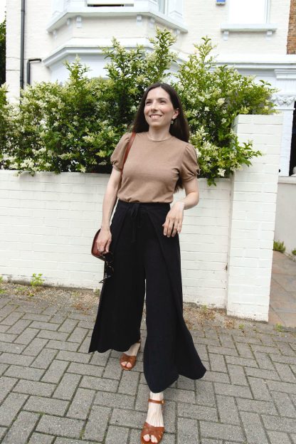 Woman wearing the Mirage Trousers sewing pattern from Camimade on The Fold Line. A wrap trouser pattern made in cotton, linen, viscose, double or triple crepe fabrics, featuring front waist ties, full length wide leg with overlapping panels.