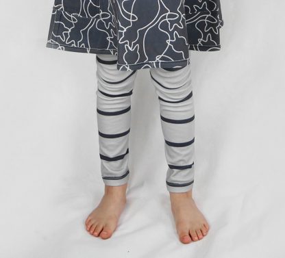 Child wearing the Children's Meow Meow Stripy Legging sewing pattern from Ruth Maddock Makes on The Fold Line. A leggings pattern made in knit fabrics, featuring an elasticated waist and full length leg.