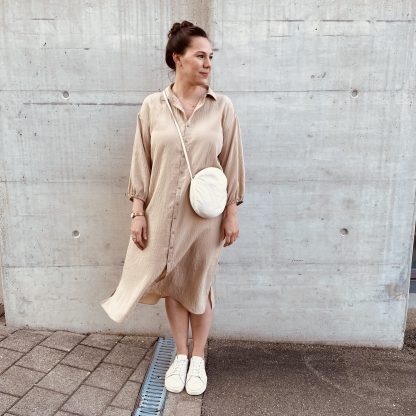 Women wearing the Alea Dress sewing pattern from Marsha Style on The Fold Line. A dress pattern made in linen, cotton, tencel, viscose, rayon or poplin fabrics, featuring dropped shoulders, ¾ sleeve with gathered cuff, classic shirt collar, front button closure, and knee length hem.