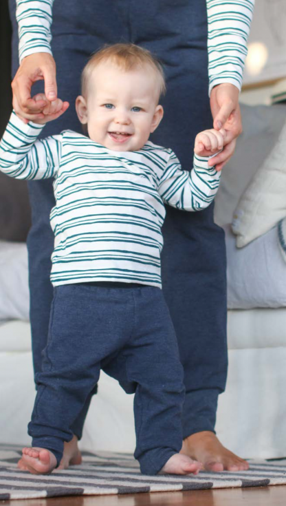 Baby wearing the Babies Fieldfare Joggers sewing pattern from Pattern by Malena on The Fold Line. A joggers pattern made in medium weight knit fabrics, featuring an elasticated waistband, wide ankle cuff and relaxed fit.
