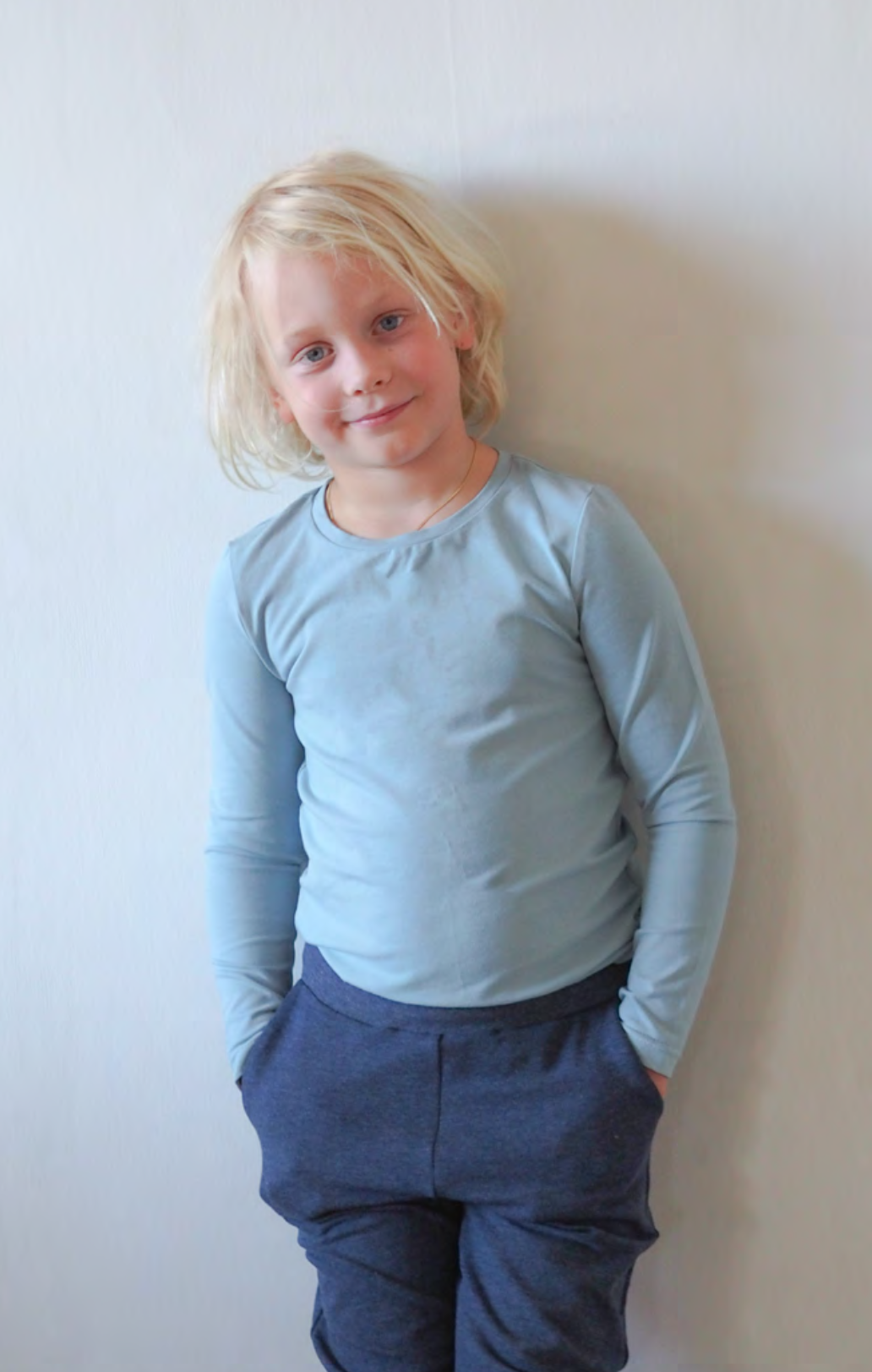 Child wearing the Hazelhen Tee sewing pattern from Pattern by Malena on The Fold Line. A knit top pattern made in rib knit fabrics, featuring a round neck with neckband and full length sleeves.