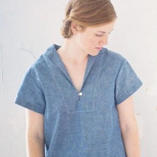 Woman wearing the Heidi Pullover Top sewing pattern from Anna Allen on The Fold Line. A top pattern made in light to medium weight woven fabrics, featuring side slits, no bust darts, short sleeves, back yoke with gathers, straight collar and front slit that opens into a v-neckline with a button and thread loop closure.