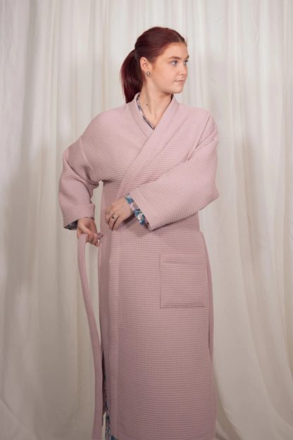 Woman wearing the Titania Robe sewing pattern from Sew Me Something on The Fold Line. A dressing gown pattern made in linen, viscose, cotton or cotton waffle fabrics, featuring full length sleeves, wrap and belt closure, patch pockets and midi length with side splits.
