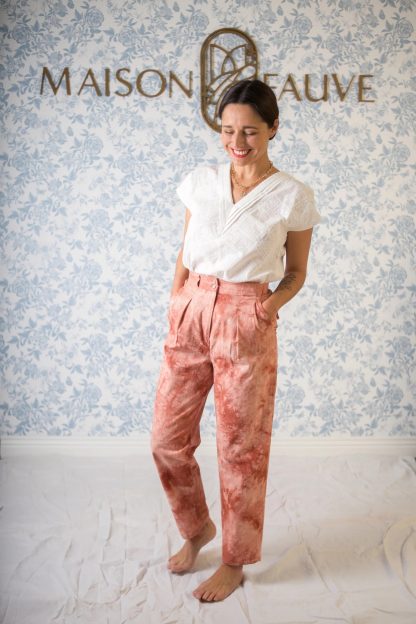 Woman wearing the Bélem Trousers sewing pattern from Maison Fauve on The Fold Line. A trouser pattern made in linen, tencel, fine denim, viscose twill, chambray or cotton fabrics, featuring a high waist, elasticated back, front pleats, belt loops, front pockets and back pocket flaps and slightly tapered legs.