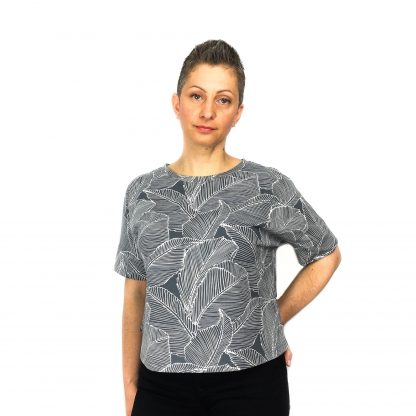 Woman wearing the Cora Tee sewing pattern from Dhurata Davies Patterns on The Fold Line. A T-shirt pattern made in light to medium weight knit/jersey fabrics, featuring a boxy shape, contrasting centre back panel, round neckline, elbow length sleeves, side vents, front hem is slightly longer and curved, while the back is shorter and straight.